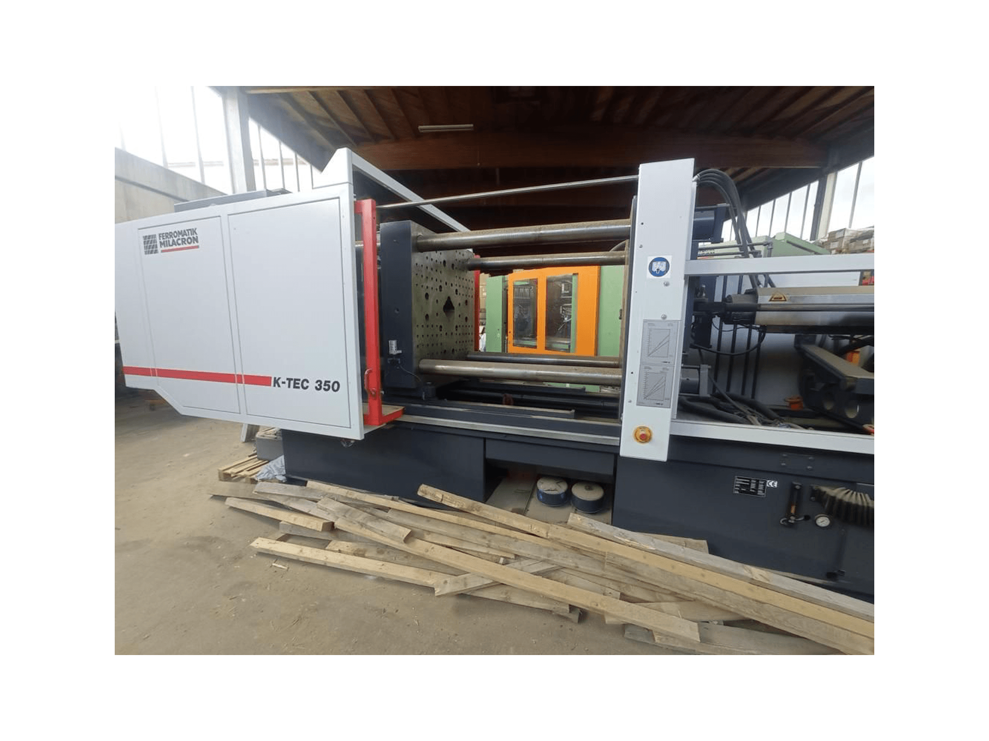 Ferromatik Milacron'dan K-TEC 350, yandan bakıldığında karmaşık makinelerini ve operasyonel kontrollerini sergiliyor.