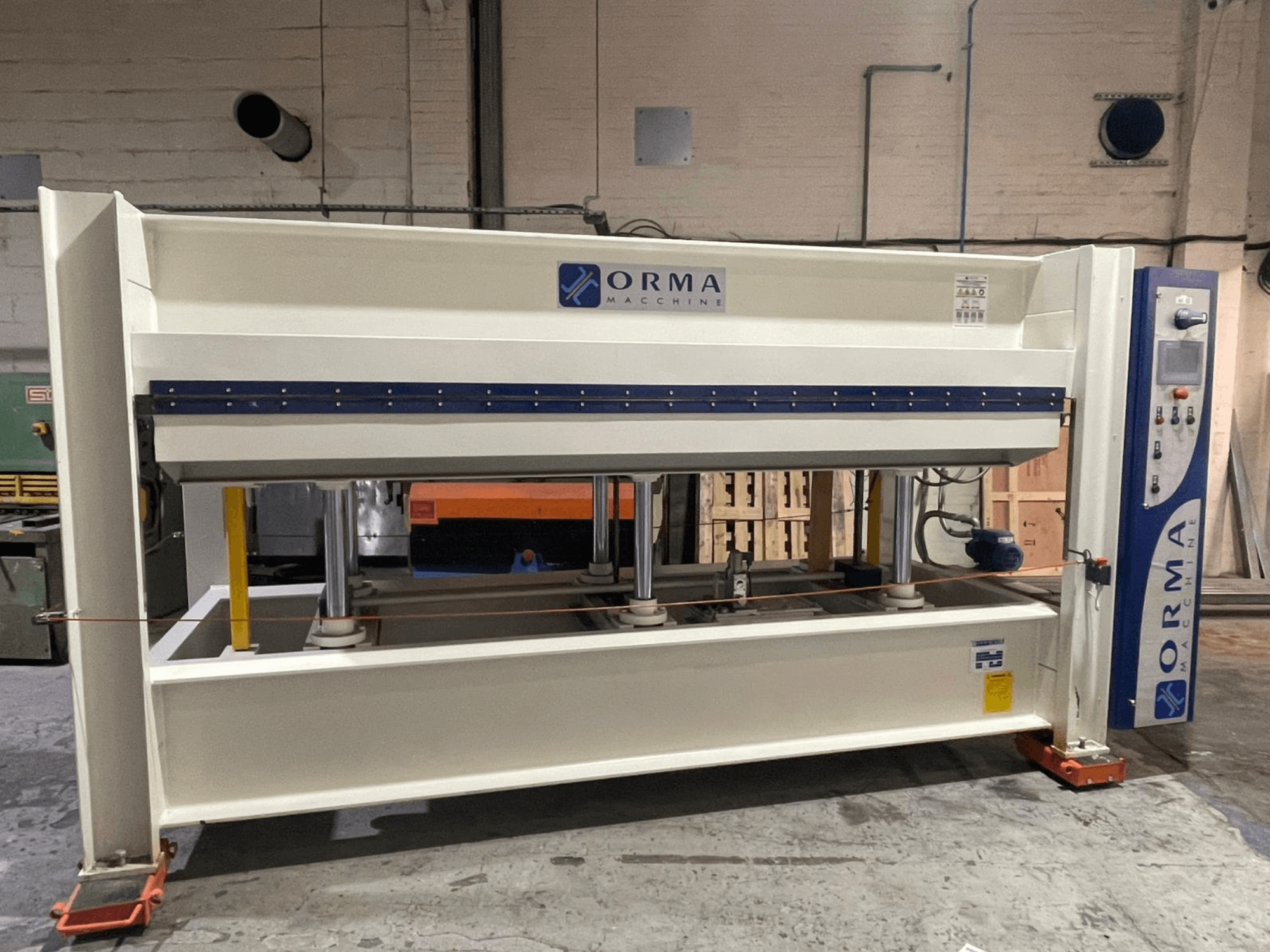 Orma Macchine hidrolik presin önden görünümü, dört dikey destek ve sağ tarafta kontrol paneli.